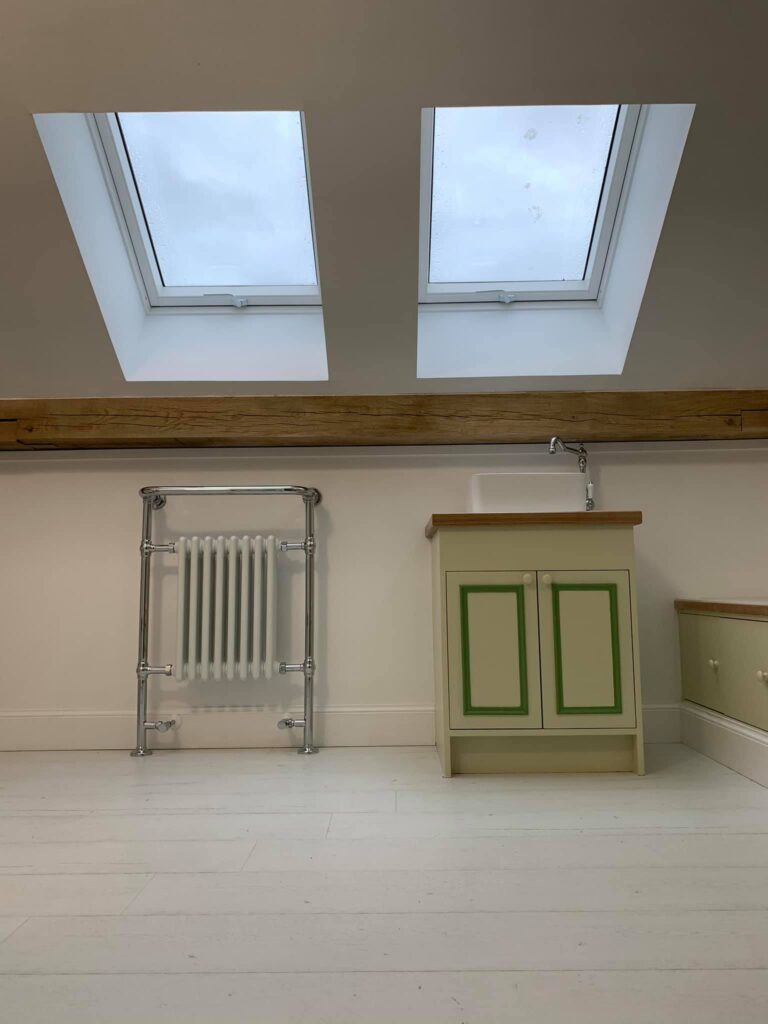 Bright room with skylights, radiator, and green cabinet.