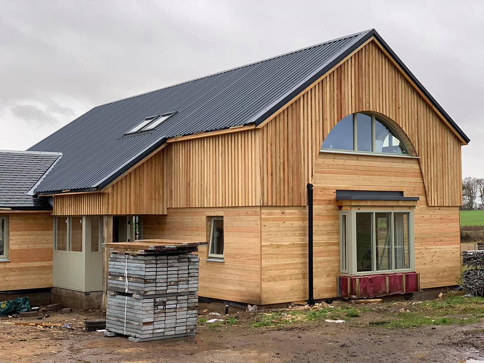 New wooden-clad rural house under construction